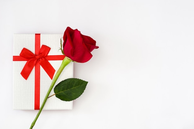 White gift box and red rose on white copy space