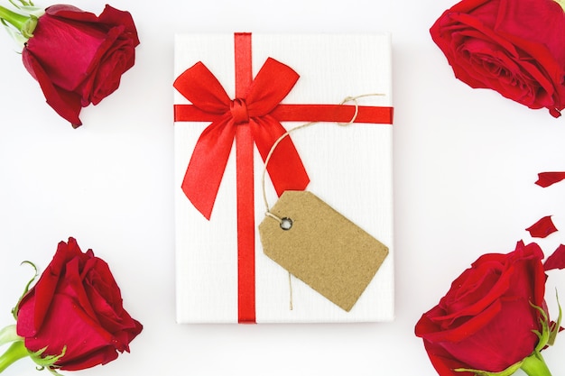 White gift box and red roses on white