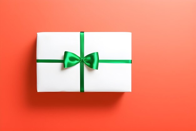 A white gift box with a green ribbon tied with a bow on an orange background.