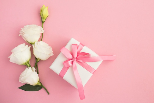 White gift box with pink bow and beautiful white flowers