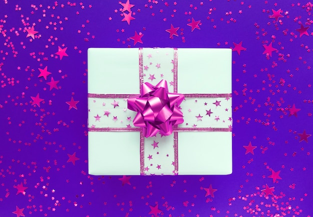 White gift box with pink bow and stars