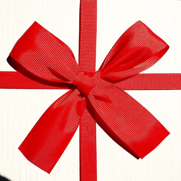 White gift box with red ribbon bow isolated on white background