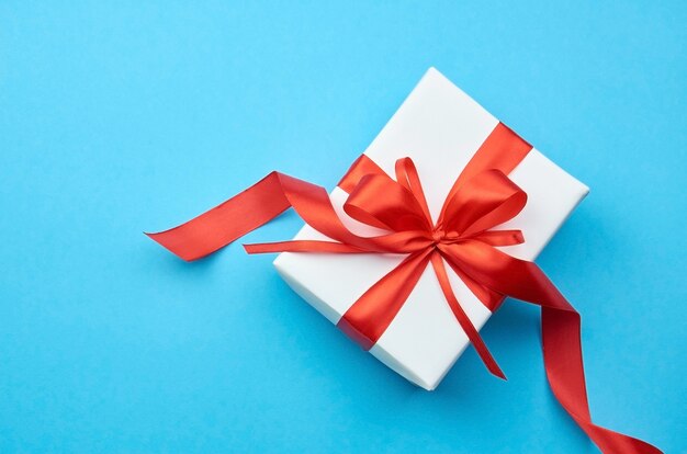 White gift box with red ribbon bow