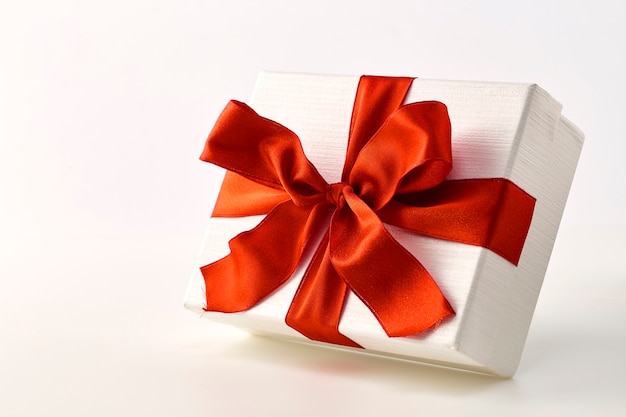 White gift box with red ribbon bow