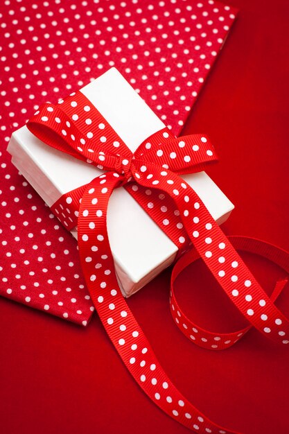 White gift box with red ribbon