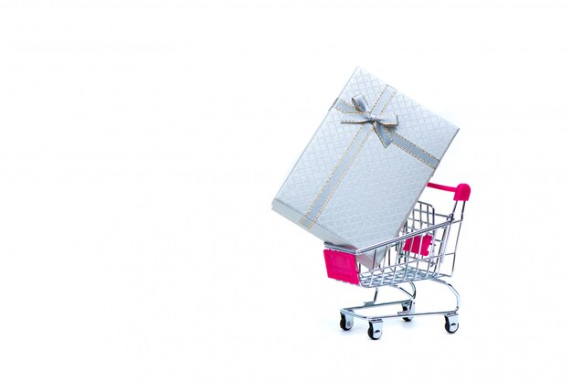 White gift box with ribbon bow and shopping cart 
