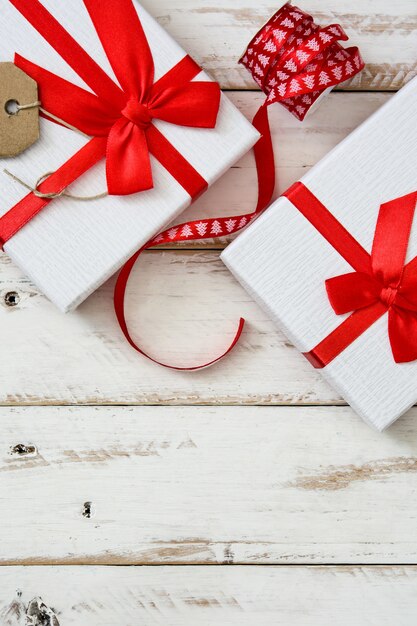 White gift with label on white wooden table copy space