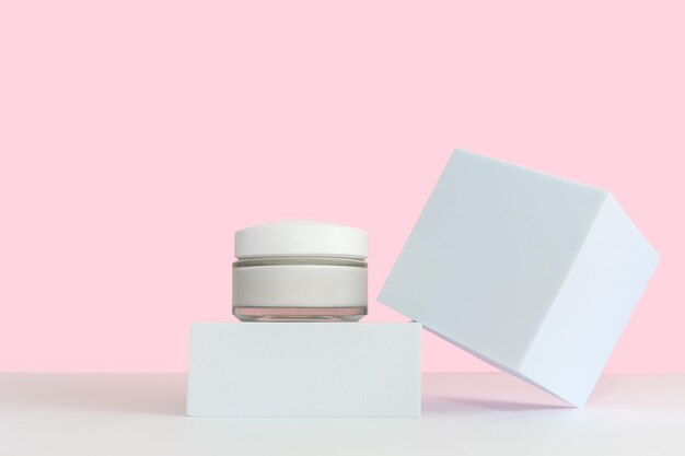 White glass cosmetic jar with cosmetic cream For body and face On a square white podium