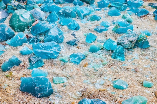 White glass covered ground with large chunks of turquoise and sky blue shards