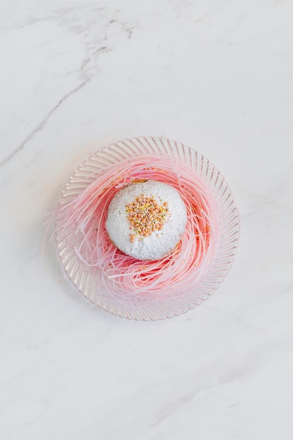 Пончик в белой глазури на розовом сахарном гнезде