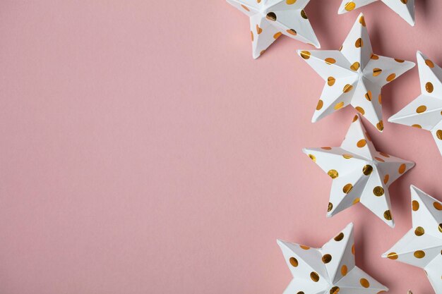 White and gold star decorations on a pastel pink Seasonal festive background