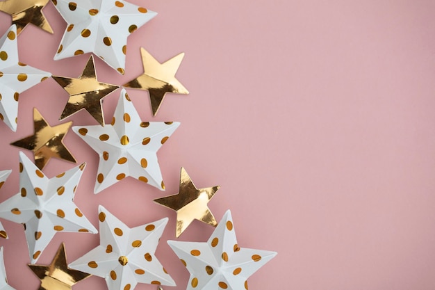 White and gold star decorations on a pastel pink Seasonal festive background