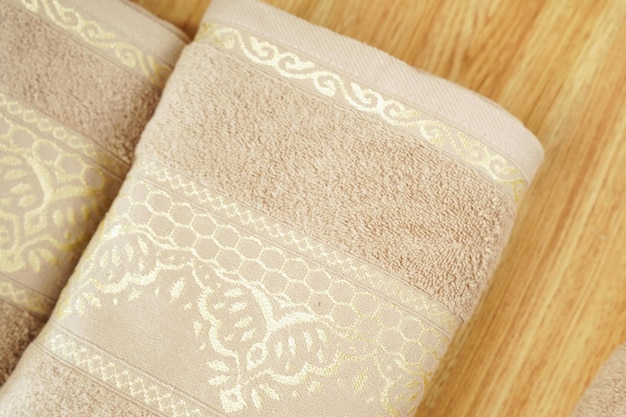 a white and gold towel with a gold design towels on wooden in bathroom decor and Spac