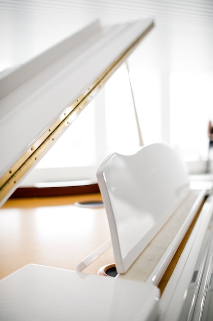 White Grand piano on white background. in a beautiful light interior.