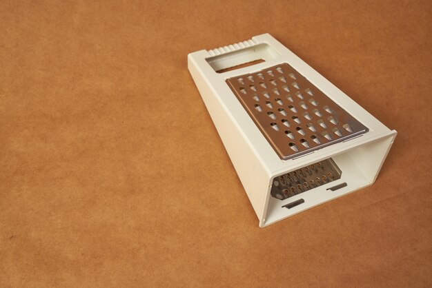 White grater on a brown background