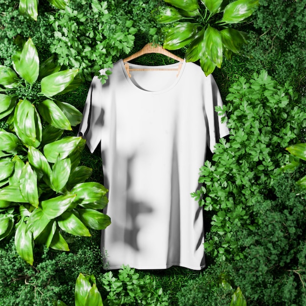 Foto maglietta bianca grigia nella giungla verde circostante con alberi e piante per il mockup 3d render