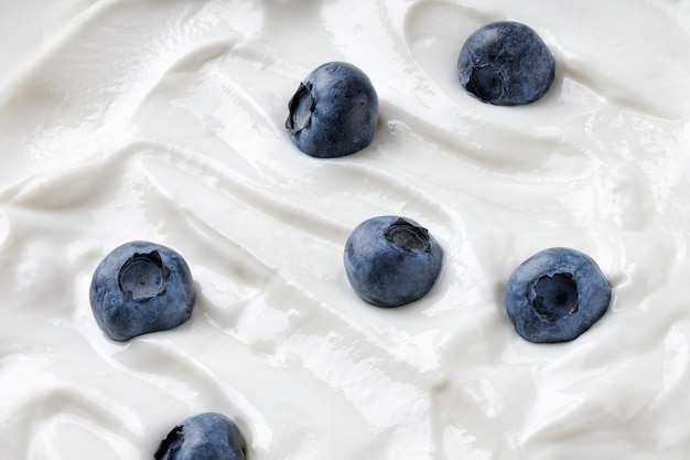 White Greek Yogurt texture Wave of yogurt with blueberry Ice cream background Tasty liquid texture