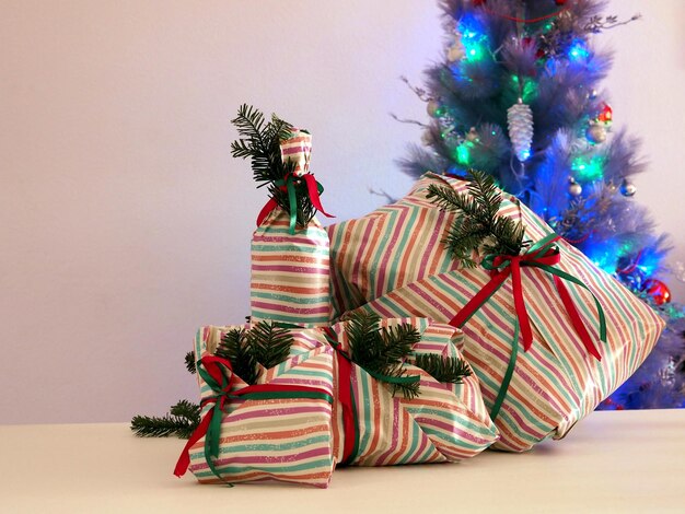 White green and red gift boxes in front of christmas tree background