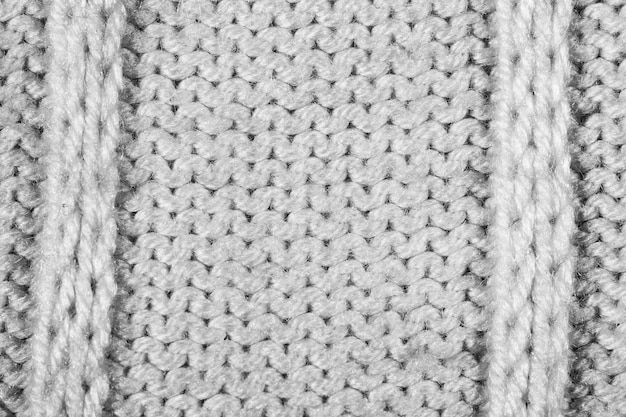 白い灰色の編み物の羊毛の質感の背景のファッションセーターの素材.