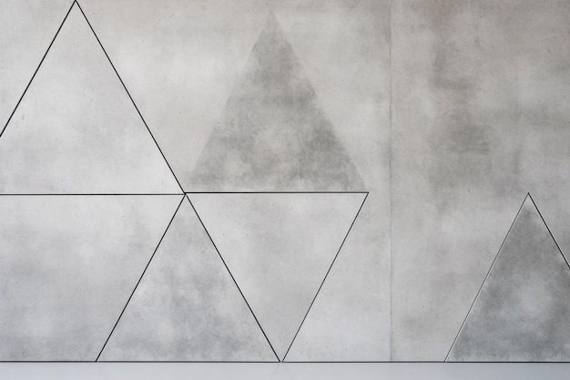 a white and grey wall with a triangle in the middle
