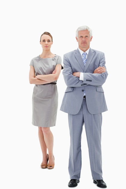 White hair businessman with a woman behind him crossing their arms