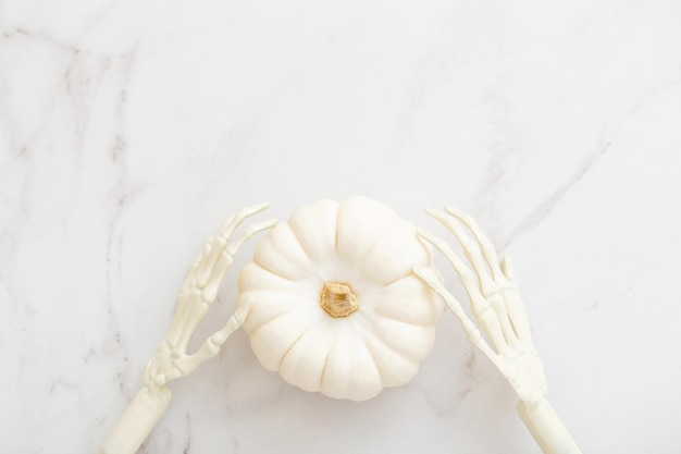 White halloween pumpkins with decor on marble background