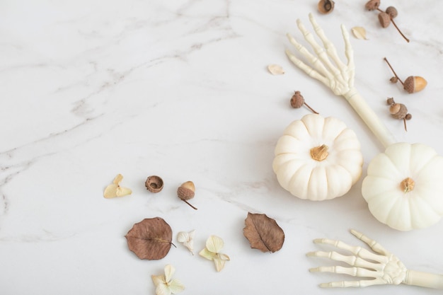 Zucche di halloween bianche con decorazioni su fondo di marmo