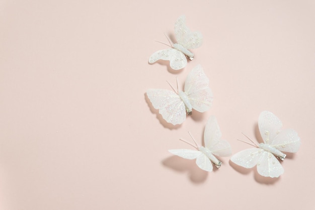 white handmade butterflies on a pale pink background banner free space for text