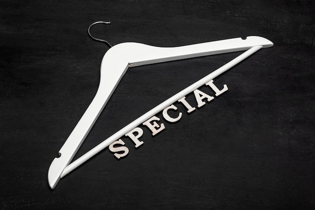 White hanger and text SPECIAL on black background. Discounts. Seasonal sale. Black friday. Special price.