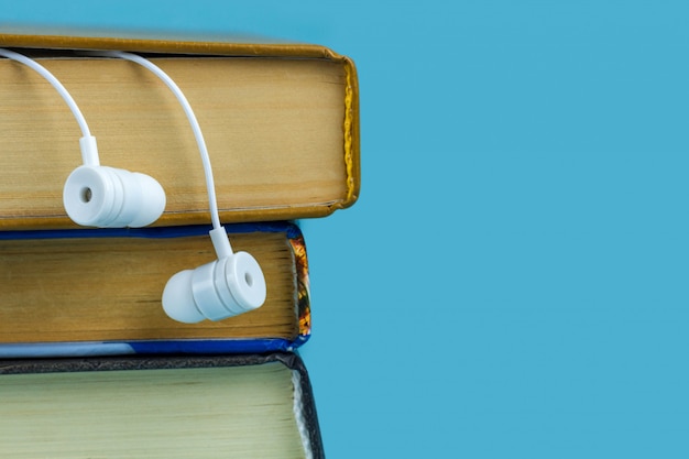 Белые наушники и книги. Концепция аудио книги.