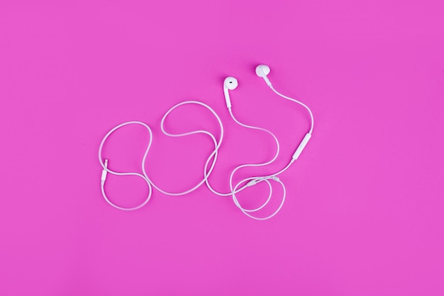 Photo white headphones for music on pink