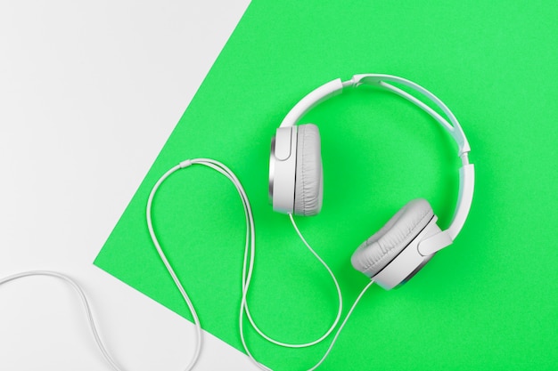 White headphones with cord on bright green background