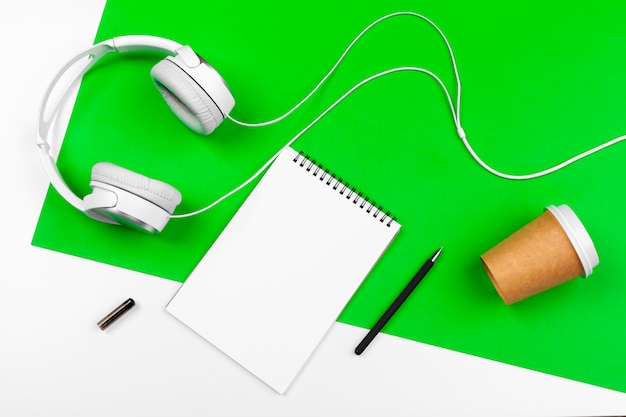 White headphones with cord on bright green background