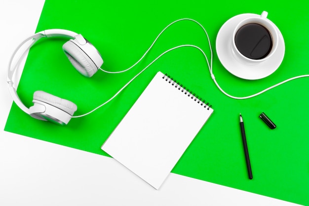 White headphones with cord on bright green background