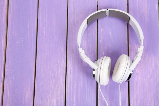 White headphones on wooden table closeup