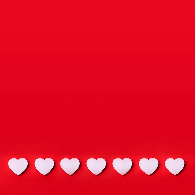 White heart cutted from paper over red background with copy space. Valentine's Day. Love, date, romantic concept.