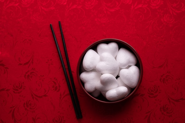 White heart shape on plate with red background, Valentine's day holiday celebration.