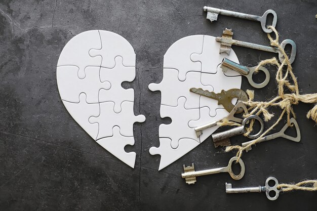 Foto puzzle a forma di cuore bianco. affari di cuore. amore indiviso. cuore spezzato. la chiave del cuore. cuore chiuso su una serratura. concetto di amore.