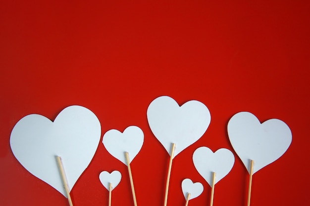 White hearts paper isolated on red background with copy space