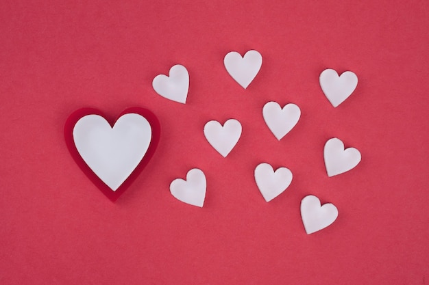 Photo white hearts on a red background top view. valentine's day.