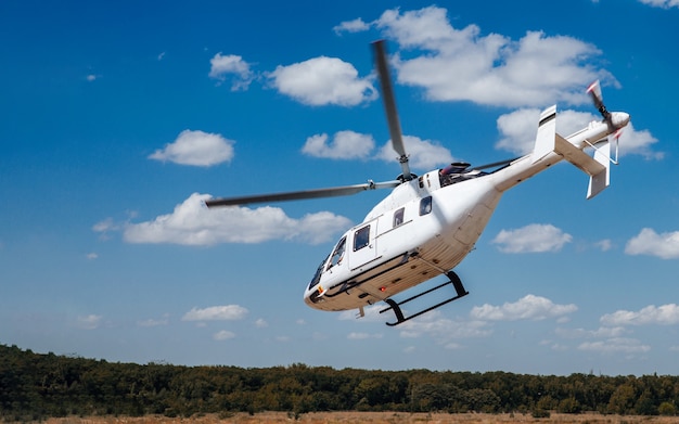 A white helicopter takes off from the runway.