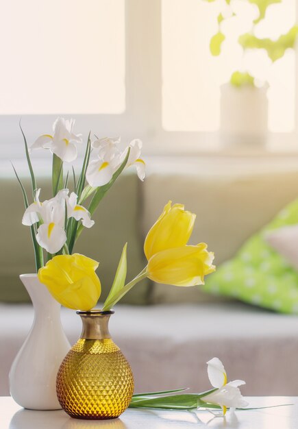 Interno domestico bianco con fiori e decorazioni primaverili