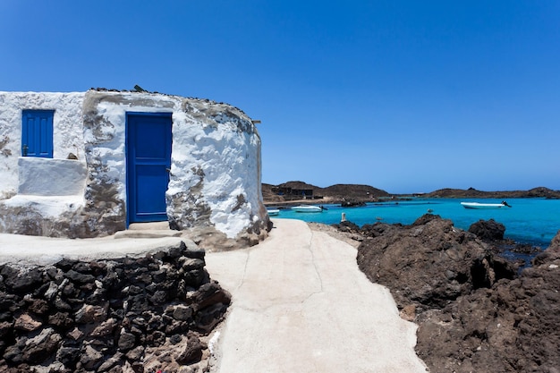 white house facing the sea with blue door