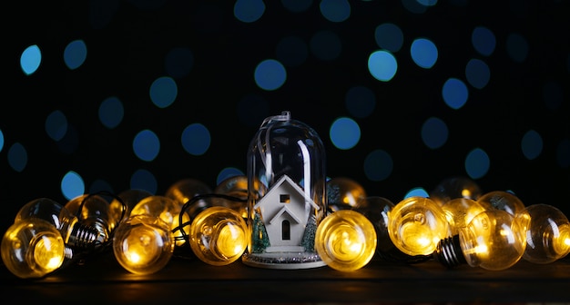 White House inside Glass Between Lights Bulb, Blue Bokeh Dark Background