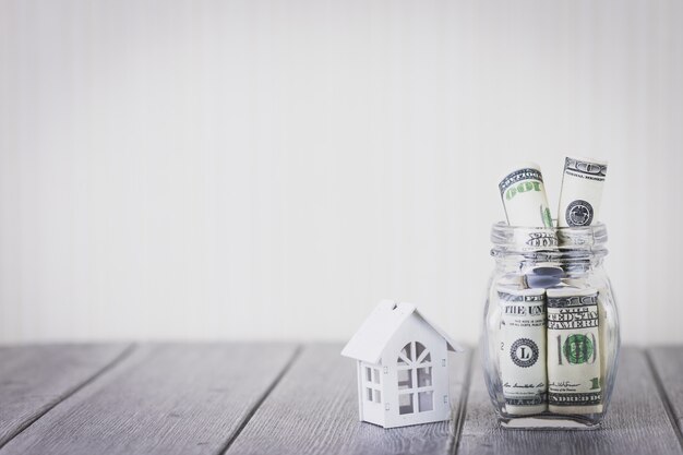 Casa bianca con centinaia di dollari in bottiglia di vetro. investimento immobiliare e mutuo casa