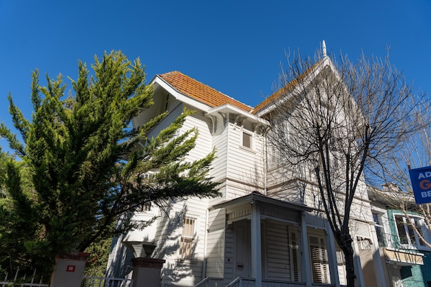 A white house with a red roof and a blue sign on the side