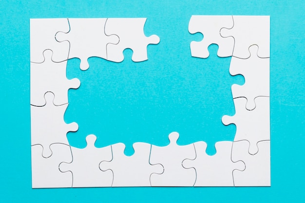 Puzzle bianco incompleto bianco su sfondo blu