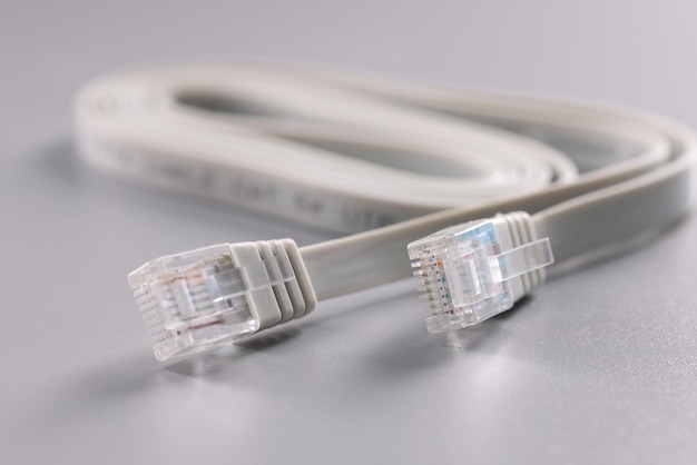 White internet connectors placed on grey surface cable with plastic clip at tip