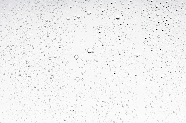 Photo white isolated background water drops on the glass / wet window glass with splashes and drops of water and lime, texture autumn background
