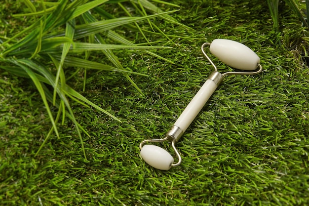 White Jade Roller Facial Massager op groen gras